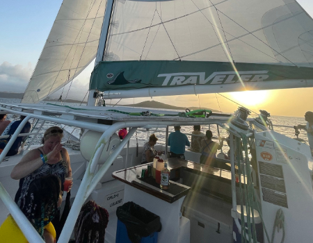 People enjoying a sunset sail on a catamaran.