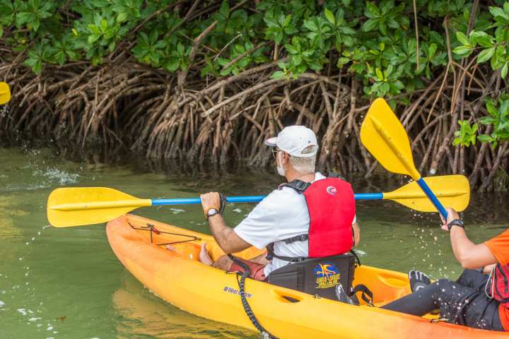 person kayaking on orange kayak